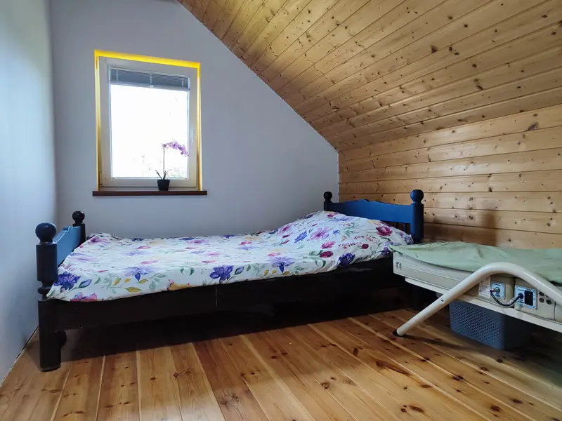 Sypialnia z drewnianym wykończeniem w Brzozowej Chatce